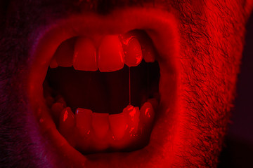 Macro closeup on man shouting with mouth wide open