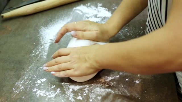 Woman's hands knead sugar mastic for making dessert