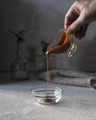 Pouring caramel sauce. Vertical. Selective focus.
