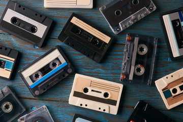 Cassette tape background, top view. Collection of a retro audio cassette on blue wooden background,...