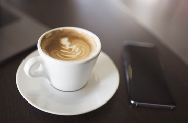 Coffee and smartphone on wooden table