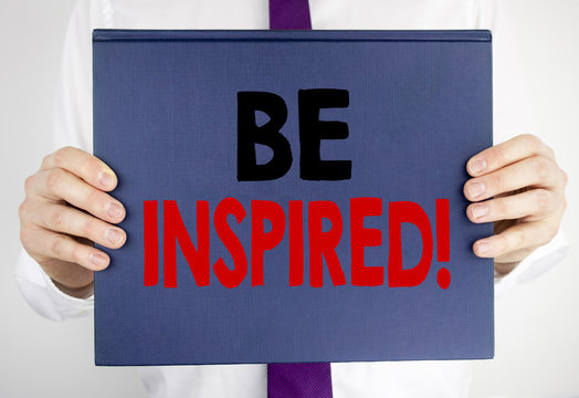 Writing text showing Be Inspired. Business concept for Inspiration, Motivation written on book notebook paper holding by the man in suit blurred background.