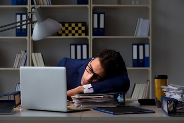 Businessman tired and sleeping in the office after overtime hour