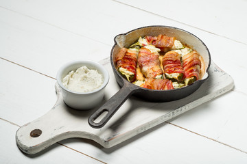 Meat bacon slices roasted in pan. White wooden background, natural light