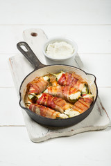 Meat bacon slices roasted in pan. White wooden background, natural light