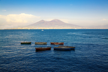 Vesuvius view from Naples bay, old boats on the sea.