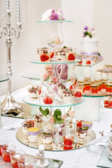 Assortment of desserts on a glass rack. Concept party, wedding, restaurant, catering, dessert.