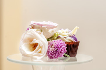 Obraz na płótnie Canvas A delicious cupcake and flowers. Concept party, wedding, restaurant, catering, dessert.