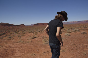 Man in hat walks in the desert