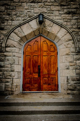 OLD WOODEN CHURCH DOOR IN BRICK WALL