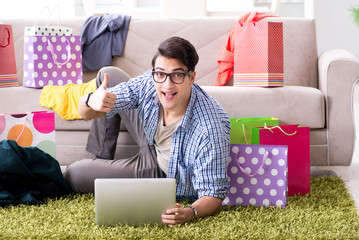 Young man buying clothing online and running blog