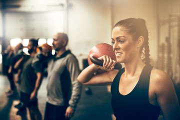 Fit woman working out with weights in an exercise class