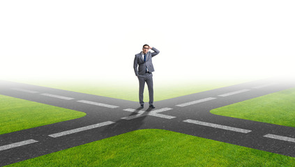 Young businessman at crossroads in uncertainty concept