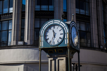 Fototapeta na wymiar Street clock on a pole. Rare metal pole with a clock.