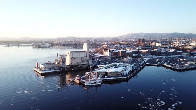 Aerial moving away shot of Opera and Lambda Munch museum in Oslo, Norway in winter