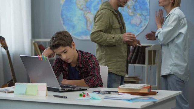 Annoyed parents quarreling behind sad childs back, family on verge of divorce