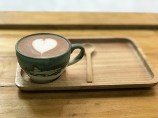 Coffe cup with heart paint on wooden table