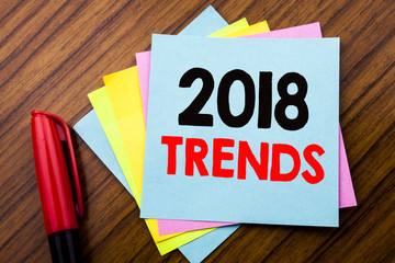 Handwriting Announcement text 2018 Trends.  Concept for Trending Data Prediction Written on sticky stick note paper with wooden background with space office view with pencil marker