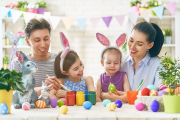 family are painting eggs