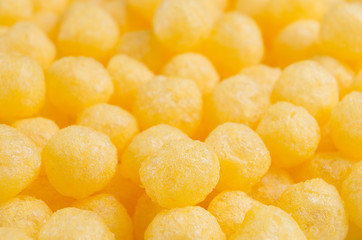 Cheesy corn sticks balls closeup as background.
