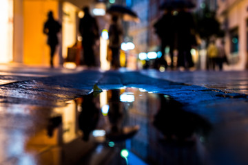Reflection of streets and people in puddles of rain