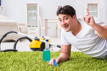 Young husband man cleaning floor at home