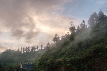 Foggy hill with colorful sky in countryside
