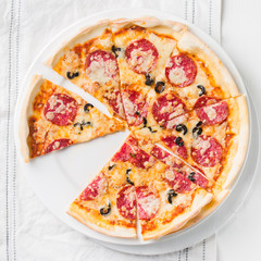 Italian Pepperoni pizza with salami on white wooden background. Italian traditional food. Popular street food. Flat lay, top view. 