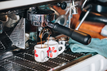 Coffee Maker making coffee flowing in cup