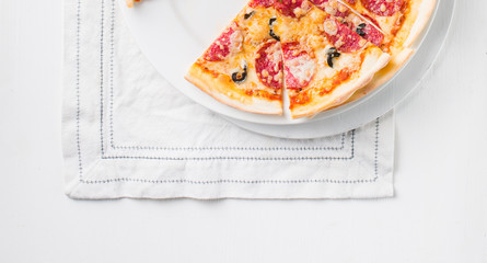 Italian Pepperoni pizza with salami on white wooden background. Italian traditional food. Popular street food. Flat lay, top view. 