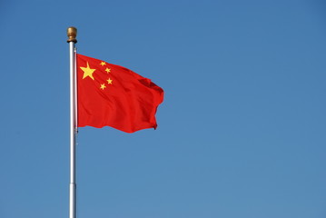 Chinese flag waving in the wind with clear blue sky