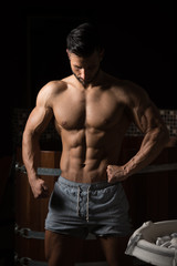 Muscular Man Flexing Muscles In Sauna