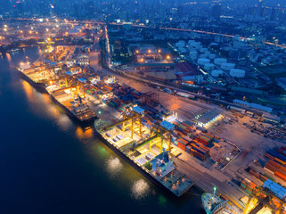 Aerial view of Containers yard in port congestion with ship vessels are loading and discharging operations of the transportation in international port.Shot from drone.