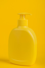 Cosmetic bottle isolated on yellow background.