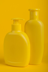 Group Cosmetic Bottles Isolated on Yellow Background.