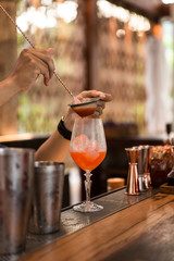 Expert barman is making cocktail at night club.