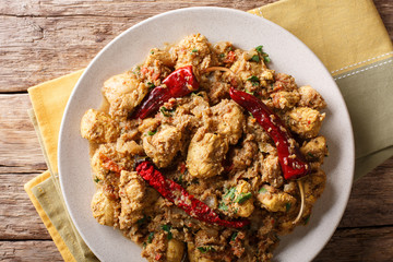Chettinad chicken curry with chili, onions, coconut and tomatoes close-up. Horizontal top view