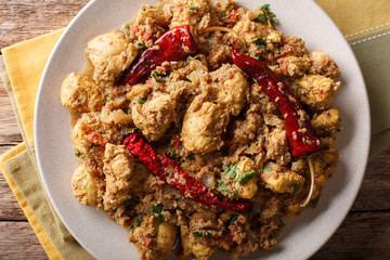 Indian spicy chettinad chicken curry with chili pepper closeup on a table. horizontal top view