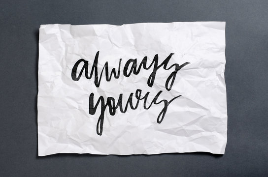 Always yours. Handwritten text on white crumpled paper. Inspirational quote.