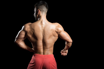 Fototapeta na wymiar Muscular Men Flexing Muscles On Black Background