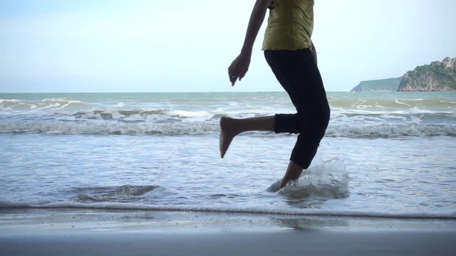 Woman runing on sand beach in Slow motion.