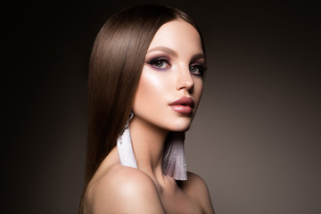 Fototapeta premium Hair. Beauty Woman with Very Long Healthy and Shiny Smooth Brown Hair. Model Brunette Girl Portrait isolated on a dark background. Gorgeous Hair