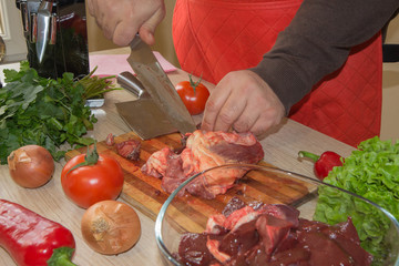 he is cutting meat or steak for a dish on wooden board