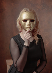 Beautiful  woman with gold carnival mask.