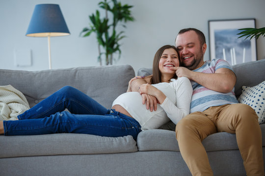 Picture of happy married couple on gray sofa