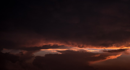 Dramatic sunset sky with orange colored clouds.