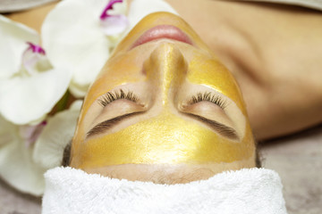 Beautiful woman with facial mask at beauty salon