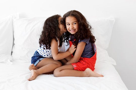 Happy little girls whispering secrets