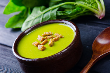 Spinach soup served on wooden board 