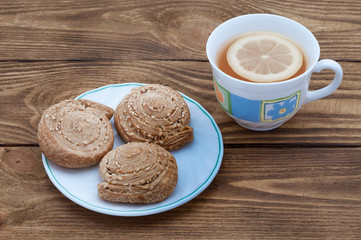 A cup of fragrant tea with lemon and homemade biscuits with sesame.